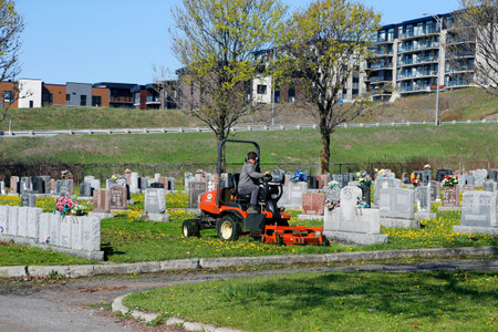 Quebec, Canada, Mowing the lawn in a cemetery in summer