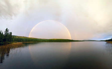 a rainbow over the lake in the forestの写真素材