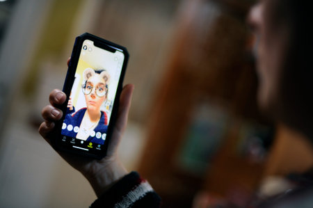 a woman uses the Snapchat app on her cellphone