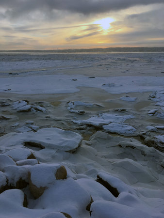 Sunrise over the frozen river in winter