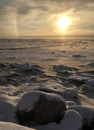 Sunrise over the frozen river in winter