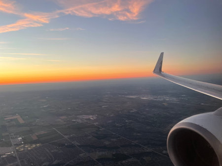 clouds in the sky from the airplane window during a sunsetの写真素材