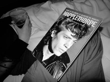 Handsome in bed reading a book. Noir et blanc. Robert Mapplethorpe, biography.のeditorial素材