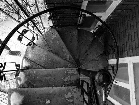 Black and white image of a spiral staircase in an old building.の写真素材