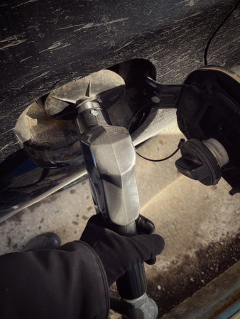 Close-up of a hand of a worker filling up a gas tank