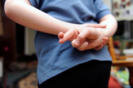 fingers crossed behind the back to cover up a lieの写真素材