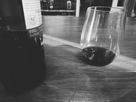 Black and white photo of a bottle of red wine and a glassの写真素材