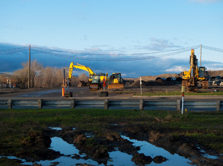 A large excavator digs a pit for the construction of a new road.
