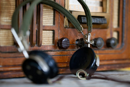 Retro radio receiver with headphones on a wooden table, close-upの写真素材