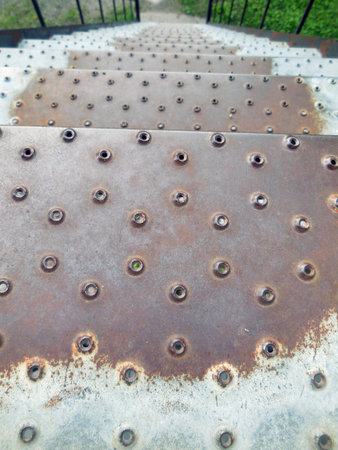 rusty metal stairs with rivets in the park, closeup of photoの写真素材