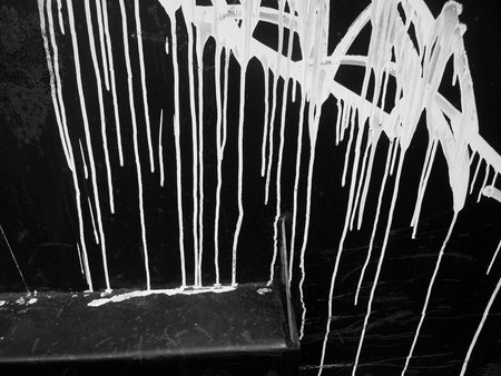 white paint on a black metal containerの写真素材