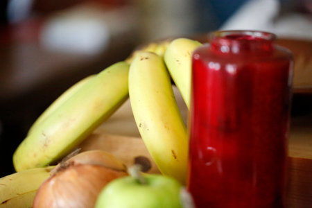 Banana juice and fresh fruits on the wooden table in the kitchenの写真素材