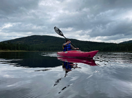 Kayaking on the lake in the mountains in a cloudy day.のeditorial素材