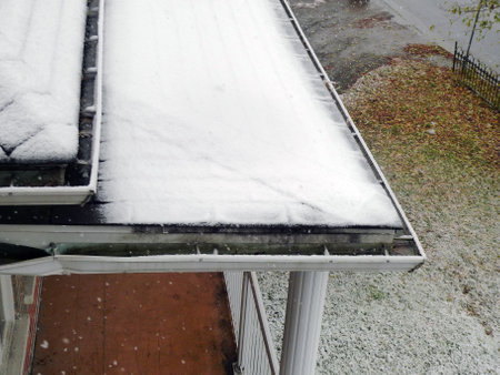 snow on the roof of a house in winter, closeup of photoの写真素材