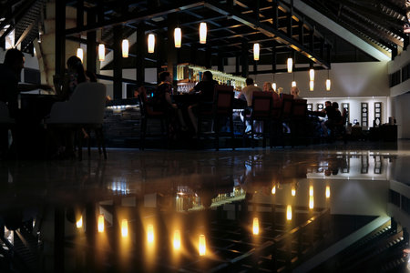 Interior of a restaurant with lights reflecting on the floor and chairsのeditorial素材