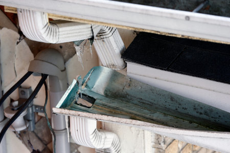 Close-up view of an old broken gutter in a building.