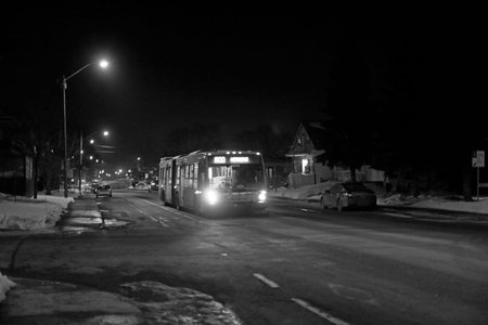 night view of a street in the center of the city in winter with a Quebec City RTC bus. Black and...