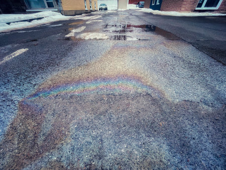 Gasoline on the sidewalk. Rainbow on wet asphalt when thawingの写真素材