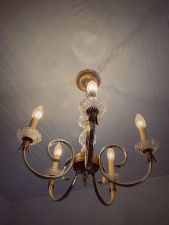 Vintage chandelier on the ceiling in a white room.