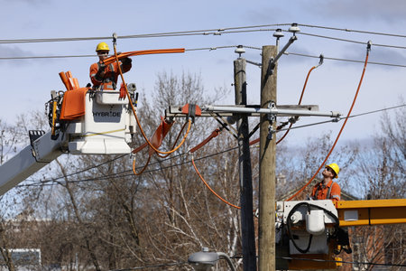 Workers on a power line on a sunny day in early spring.のeditorial素材
