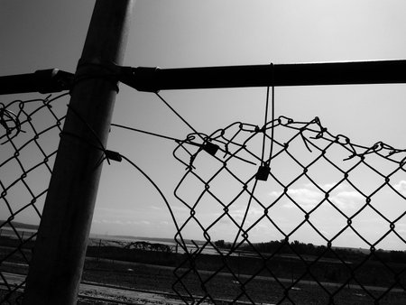 Old fence with chain link fence and cloudy sky. Black and white photos.