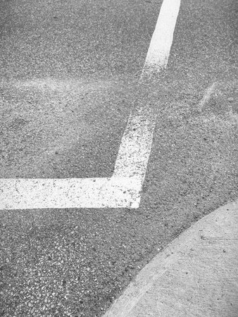 White line on the asphalt road. Black and white toned.