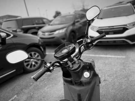 Black and white image of a scooter parked in the city.の写真素材