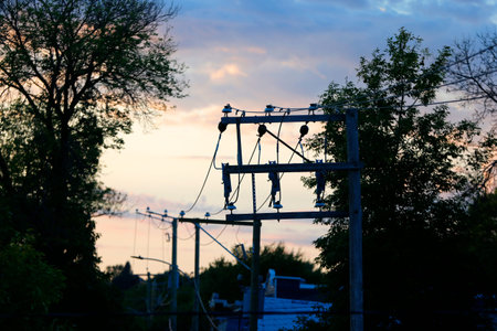 Electricity post at sunset. High voltage power lines on the background of the setting sun.