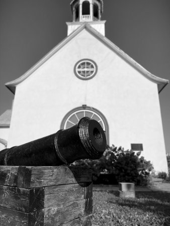 Black and white image of an old cannon in front of a church in Wendakeの写真素材