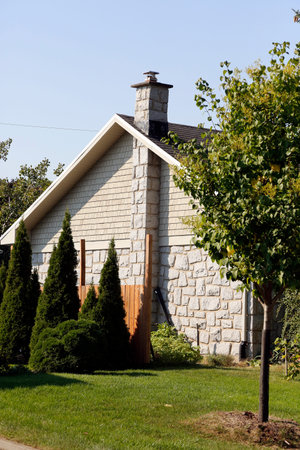 Roof of a house with a chimney on a background of autumn leavesの写真素材
