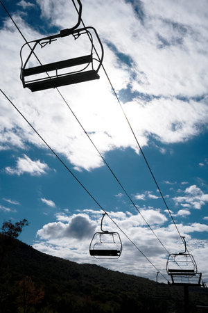 Ski lift in the mountains on a background of blue sky with cloudsの写真素材