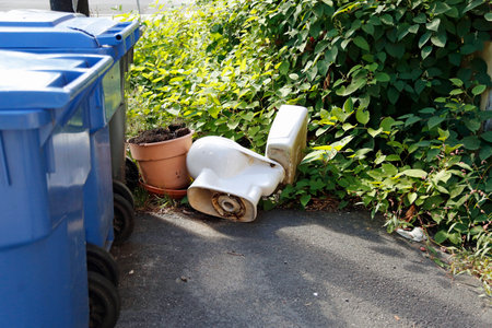 Old abandoned toilet and trash can on the street.の写真素材
