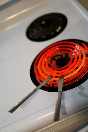 Close up of a hot element of a stove with knives.