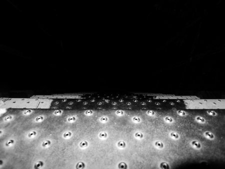 Metal plate with rivets in black and white. Abstract background and texture for design. Exterior metal stairs. Black and white photos.の写真素材