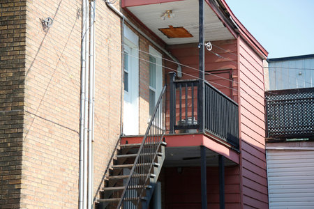 Facade of an old house with stairs and balconies in the street