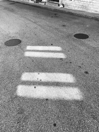 Shadow of a pedestrian crossing on the road. Black and white.の写真素材