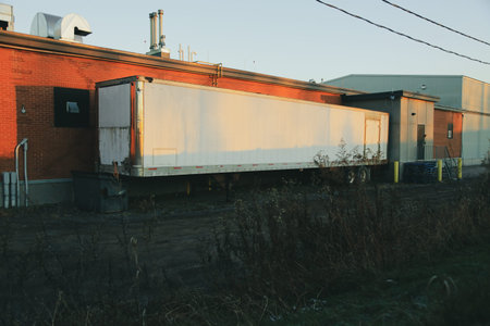 Truck with a trailer on the background of the industrial building.