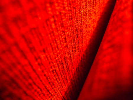 red fabric texture with some smooth lines in it - abstract photo backgroundの写真素材