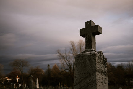 Cross in the old cemetery with cloudy sky background. Selective focus.