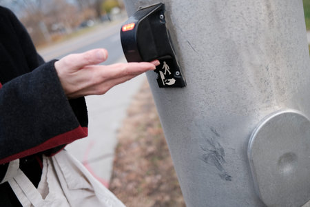 Close up of woman's hand pressing a button on a street light