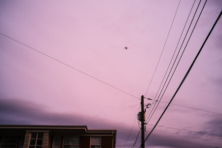 Airplane flying over a residential area in the evening.