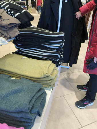 colorful sweaters in the shop, closeup of photo. Clothes on a shelf in a shop, closeup of photoのeditorial素材