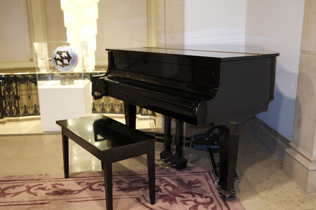 Black grand piano in a hotel lobby. Musical instrument for playing music.のeditorial素材