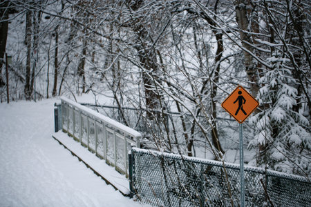 Traffic sign on the bridge over the river in winter forest.の写真素材