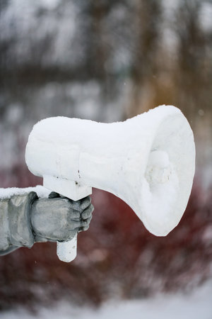 Megaphone in hand on a background of snow-covered trees