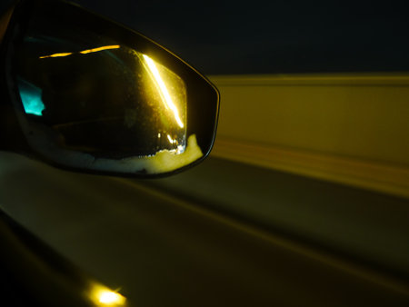 Close up rear view mirror of car at night with motion blur.の写真素材