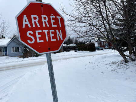 A red stop sign on a snow covered street in the town. A stop on the Huron Wendat reserve in Quebecの写真素材