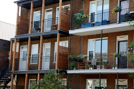 Facade of a modern apartment building with balconies and plants. An exterior balcony of an apartment...