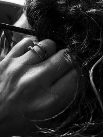 Black and white image of a woman's hand holding her hair.の写真素材