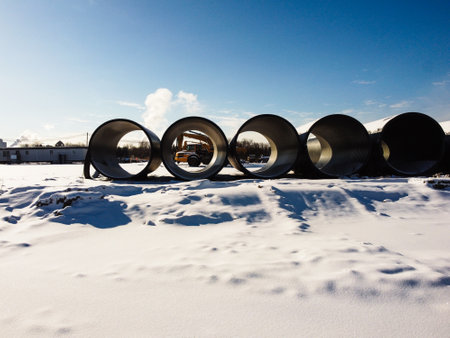 Construction of a large diameter of the pipeline in the winter. Site under construction with heavy machinery and pipelines in winter.の写真素材